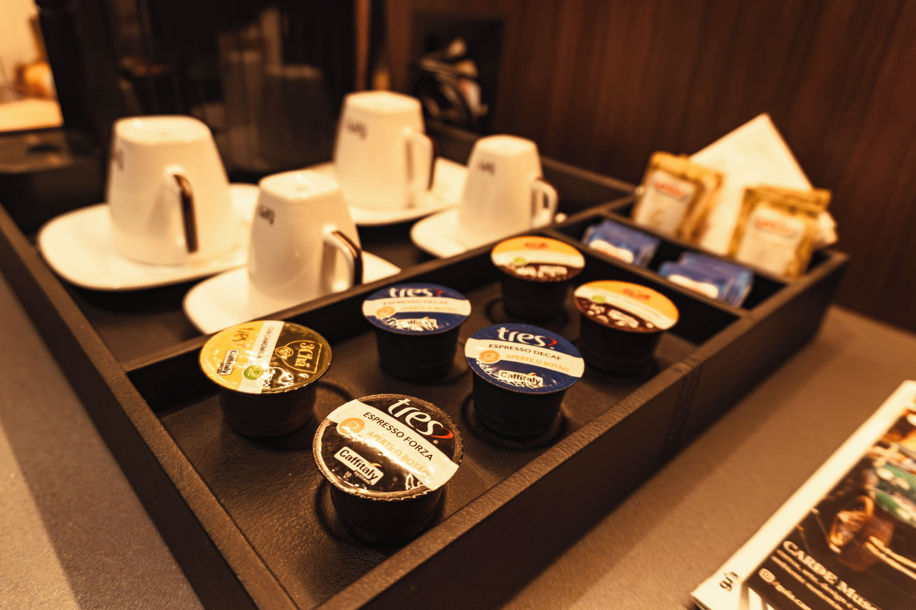 A coffee station with various coffee cups and containers, including espresso and latte options.