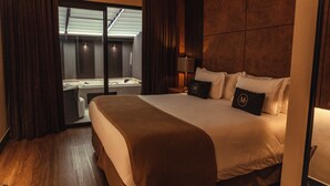 Habitación de hotel con una cama grande, un escritorio con silla, una ventana con cortinas y vista a una piscina.