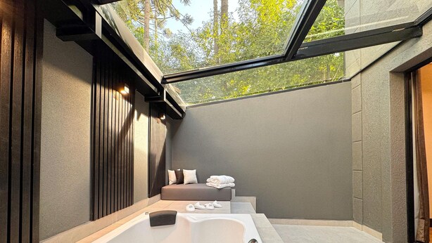 Un baño moderno con una bañera grande, una zona de ducha separada y un tragaluz.