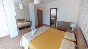 Een moderne slaapkamer met een groot bed, een spiegel en een houten nachtkastje.