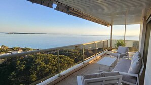 A balcony with a view of the sea, white outdoor furniture, and a potted plant. - Dream apartment with sea view (Cannes)
