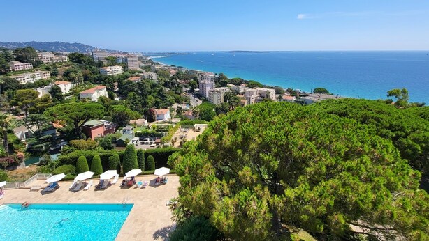 A coastal resort with a swimming pool, sun loungers, and a view of the sea. - Dream apartment with sea view (Cannes)
