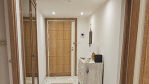 A hallway with a wooden door, a white cabinet, and a marble floor. - Dream apartment with sea view (Cannes)