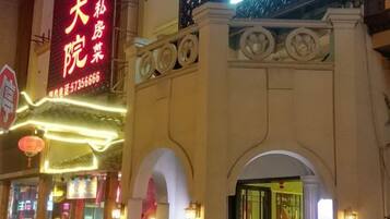 A traditional building with a prominent red sign, arched entrance, and decorative lighting.