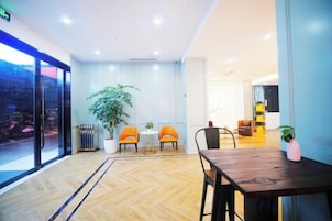 Un lobby moderno de hotel con un ventanal grande, una recepción y un área de estar.