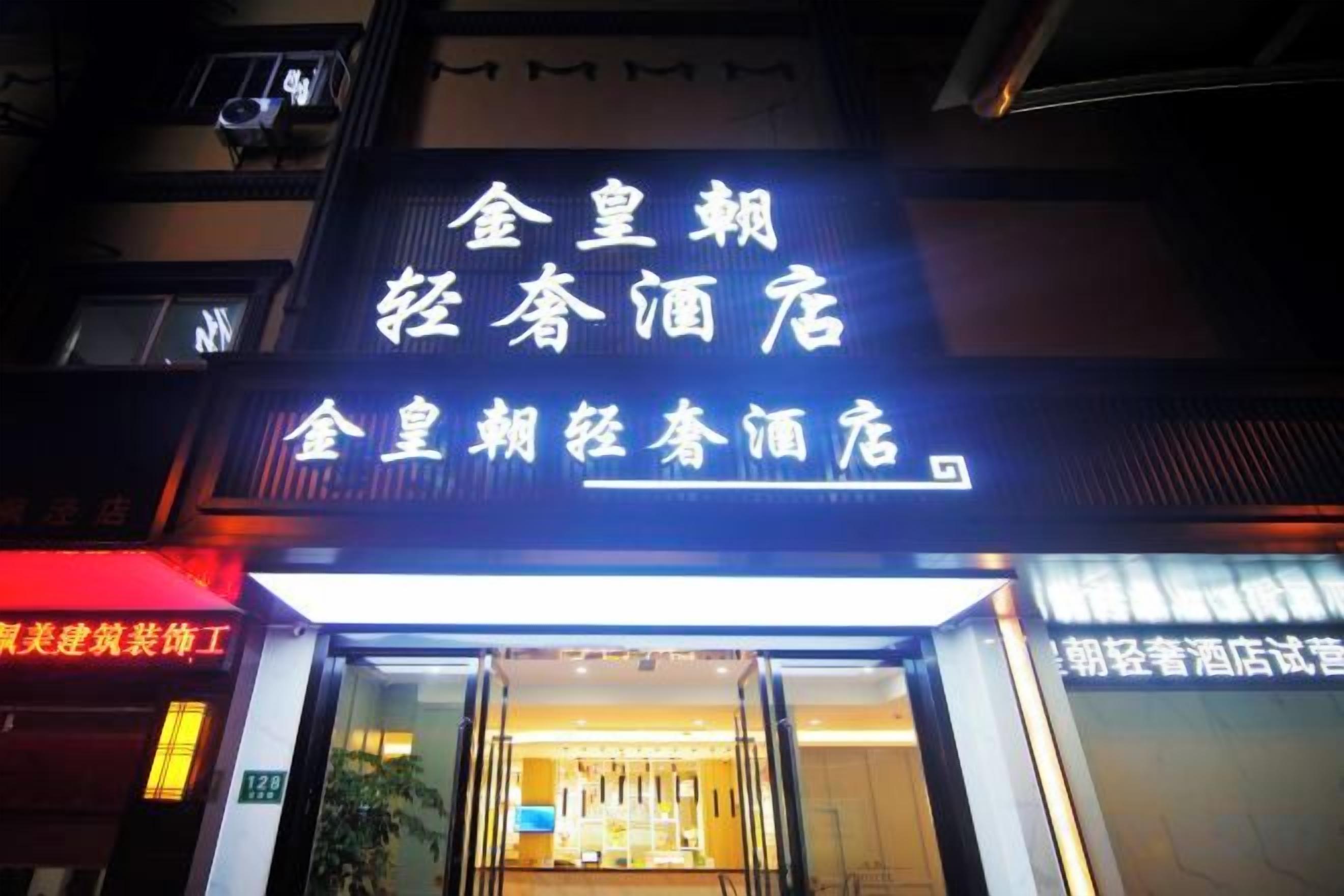 A hotel entrance with illuminated signage and a visible entrance door.