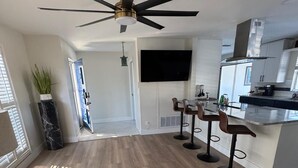A modern kitchen with a central island, bar stools, and a ceiling fan. - Paradise Lake (Clearwater)