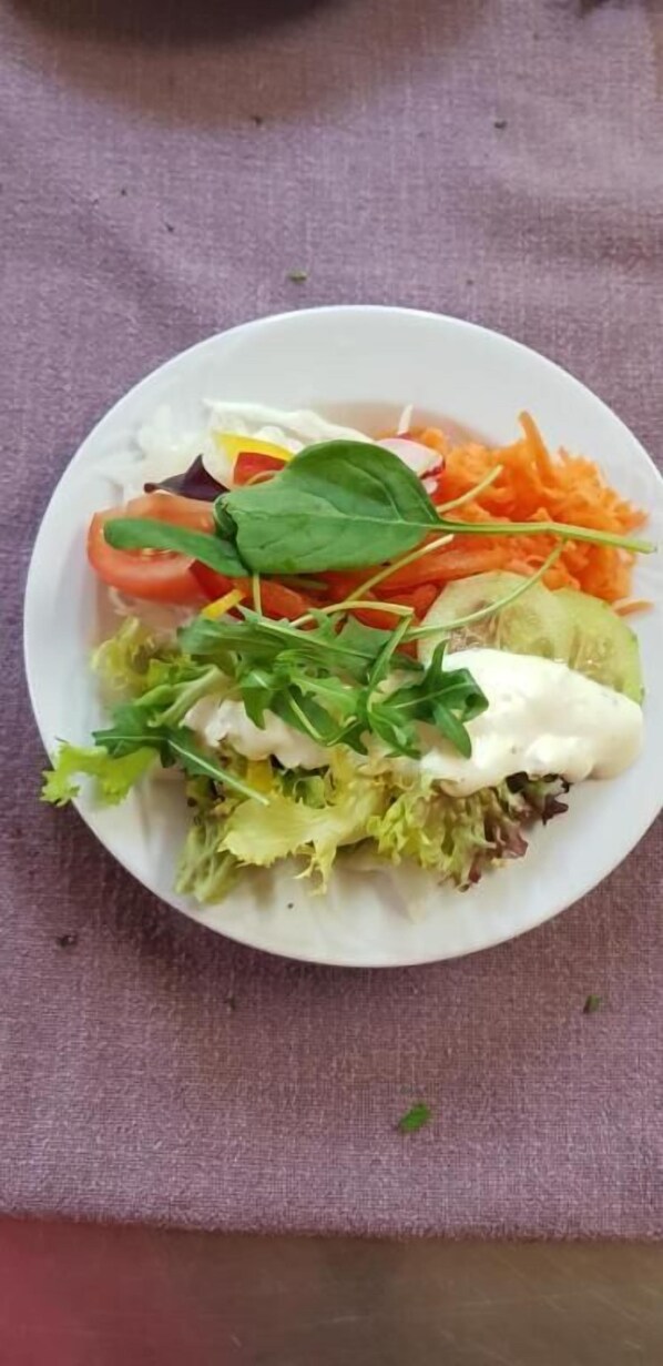 En tallrik med blandade grönsaker och sallad på ett bord.