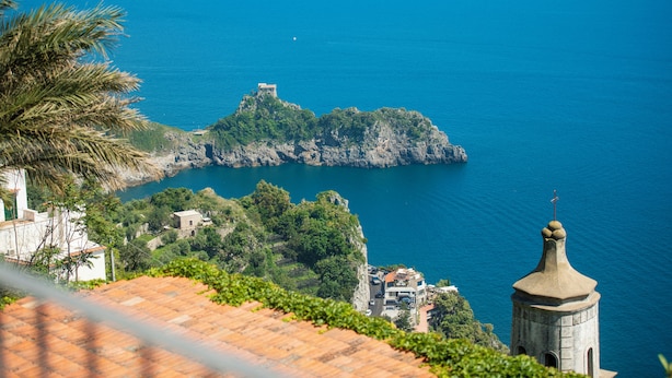 A coastal view with a prominent building on a cliff overlooking the sea. - Amalfi residence (Conca dei Marini)