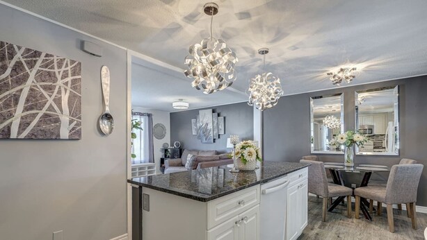 A modern kitchen with a central island, pendant lights, and a dining area with chairs and a table. - Spacious Pool House – 5 Minutes to Elgin Centre (St. Thomas)
