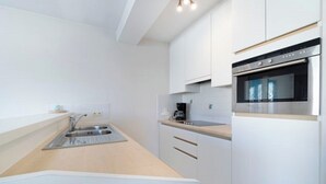 A modern kitchen with white cabinets, a stainless steel oven, and a wooden countertop. - Apartment in Middelkerke With Sea View (Middelkerke)