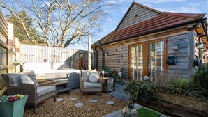 A wooden cabin with a hot tub, outdoor seating, and a garden area. - Peaceful barn stay near Lymington with private garden (Lymington)
