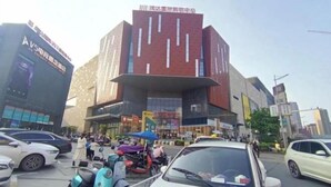 Un bâtiment moderne doté d’une façade rouge remarquable et de fenêtres verticales.