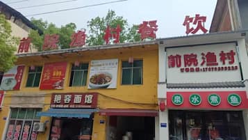 A row of storefronts with signage for restaurants and a water feature.