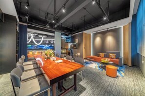 A modern conference room with a long table, multiple chairs, a sofa, and a television. - Mandu Hotel (Weifang)