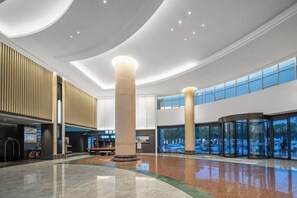 A spacious lobby with a high ceiling, large pillars, and a central seating area. - Mandu Hotel (Weifang)