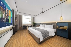 A modern hotel room with a large bed, a desk, and a TV displaying a weather forecast. - Mandu Hotel (Weifang)