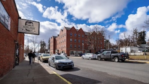 A street with parked cars and a building with a sign for 'Barrelhouse Pub & Pizza'. - Brewster Hall (Cheney)