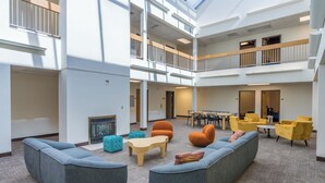 A spacious indoor area with multiple seating arrangements, including sofas and chairs, and a central table. - Brewster Hall (Cheney)