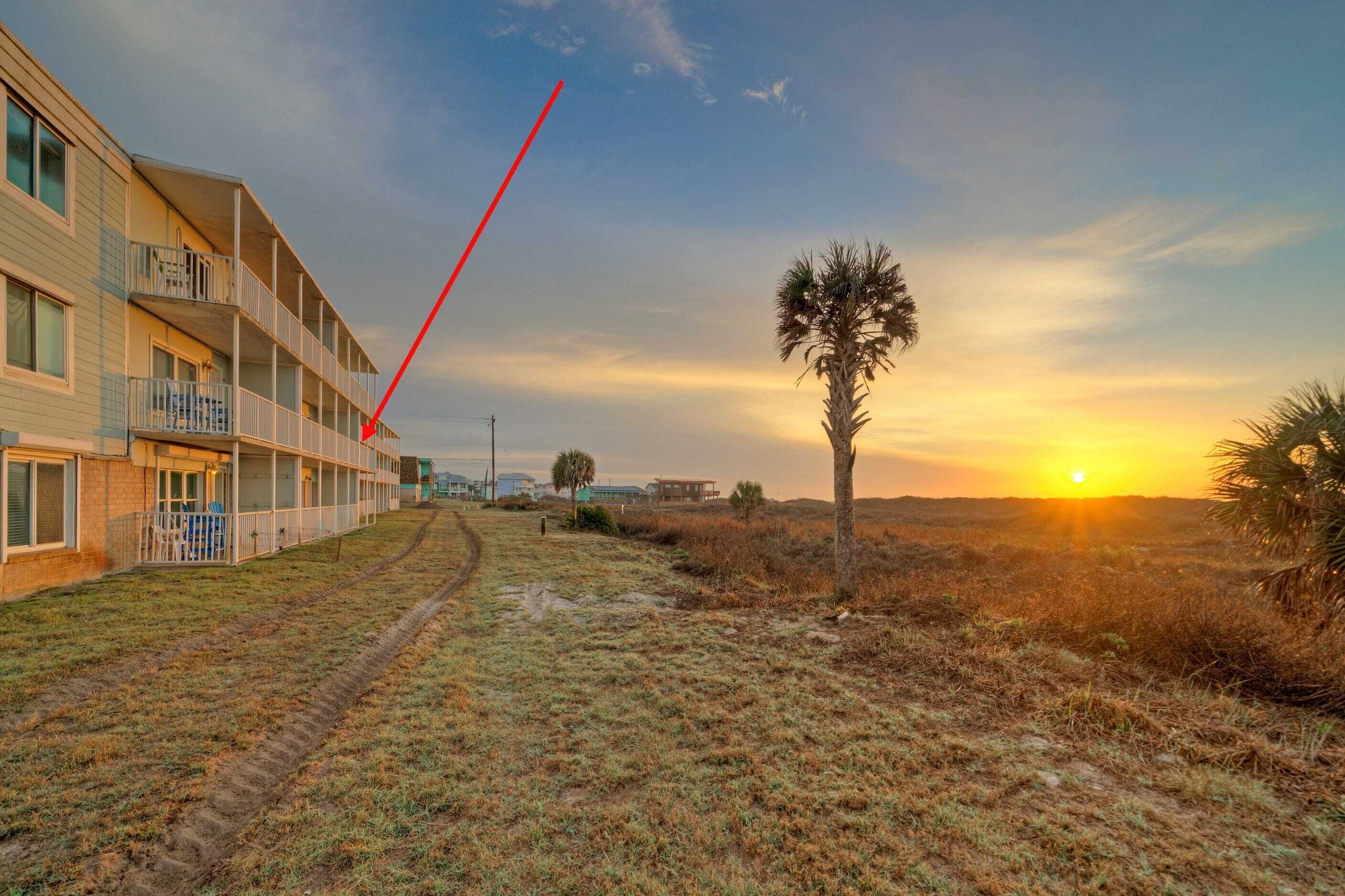 A building with multiple balconies and a clear view of the sunset.