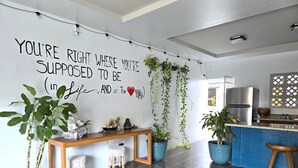 Une cuisine moderne avec un mur décoratif, une table en bois et des plantes en pot.
