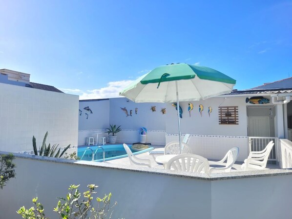 Piscine extérieure, parasols de plage, chaises longues