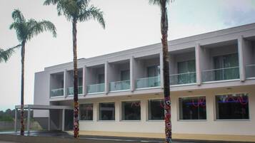 Um edifício moderno com várias varandas e janelas grandes.