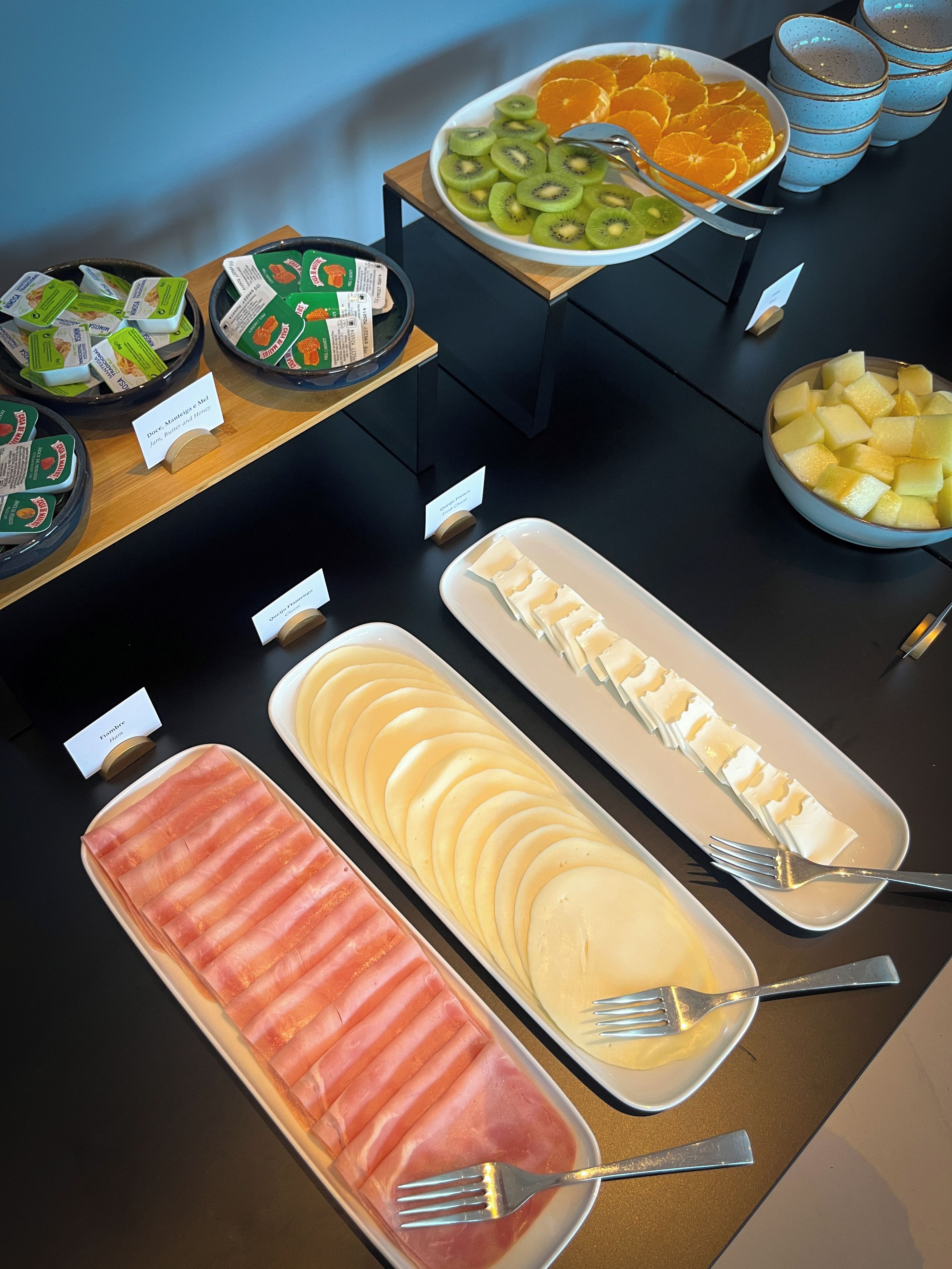 Un buffet proposant une variété de plats, notamment des fruits, des fromages et des viandes.