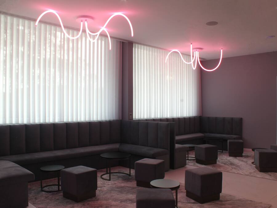 A modern lounge area with a sectional sofa, round tables, and ottomans.