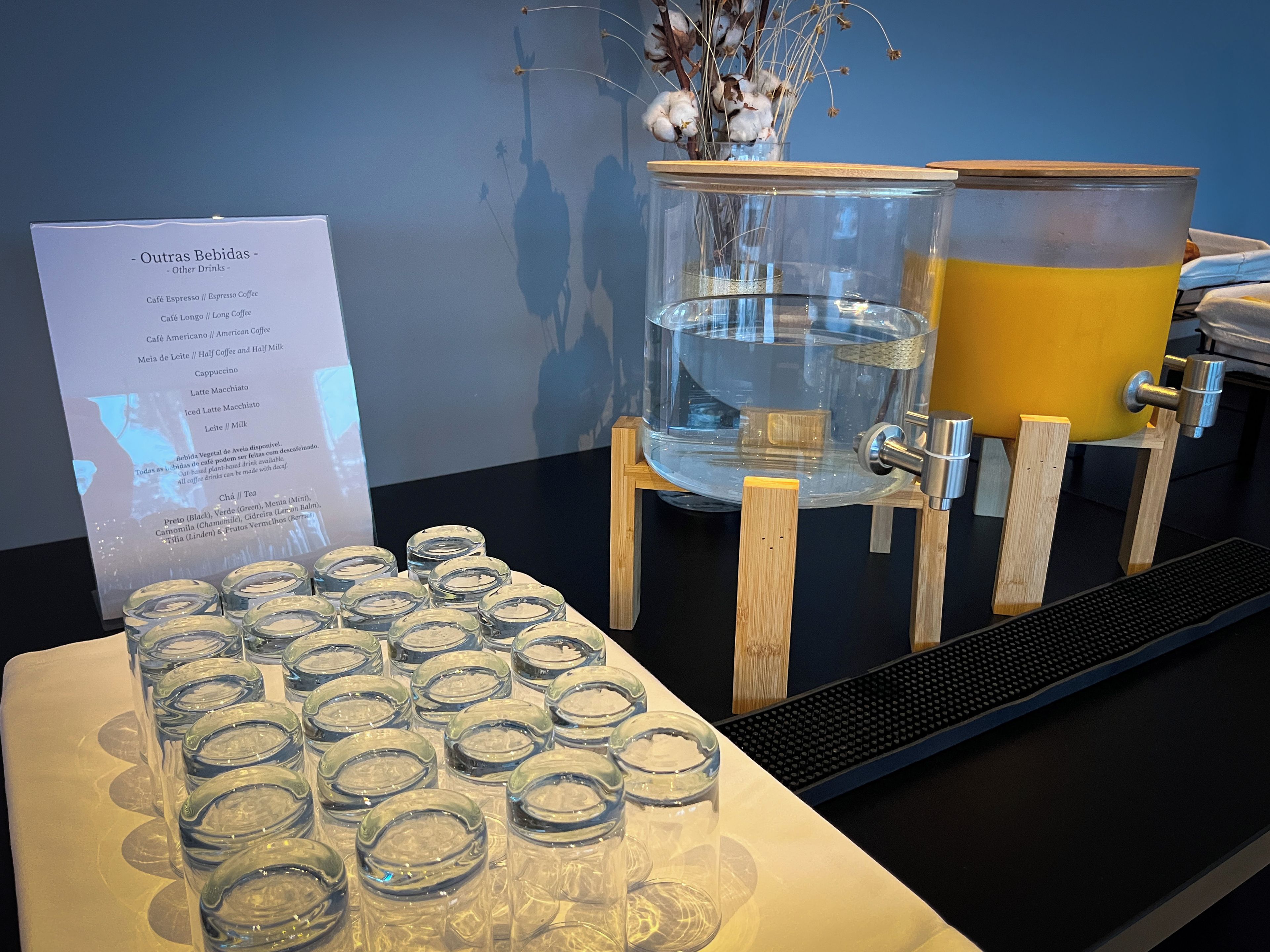 A coffee station with a menu board, a water dispenser, and a coffee machine.