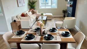 Un coin repas avec une table en bois dressée pour quatre personnes, entourée de quatre chaises.