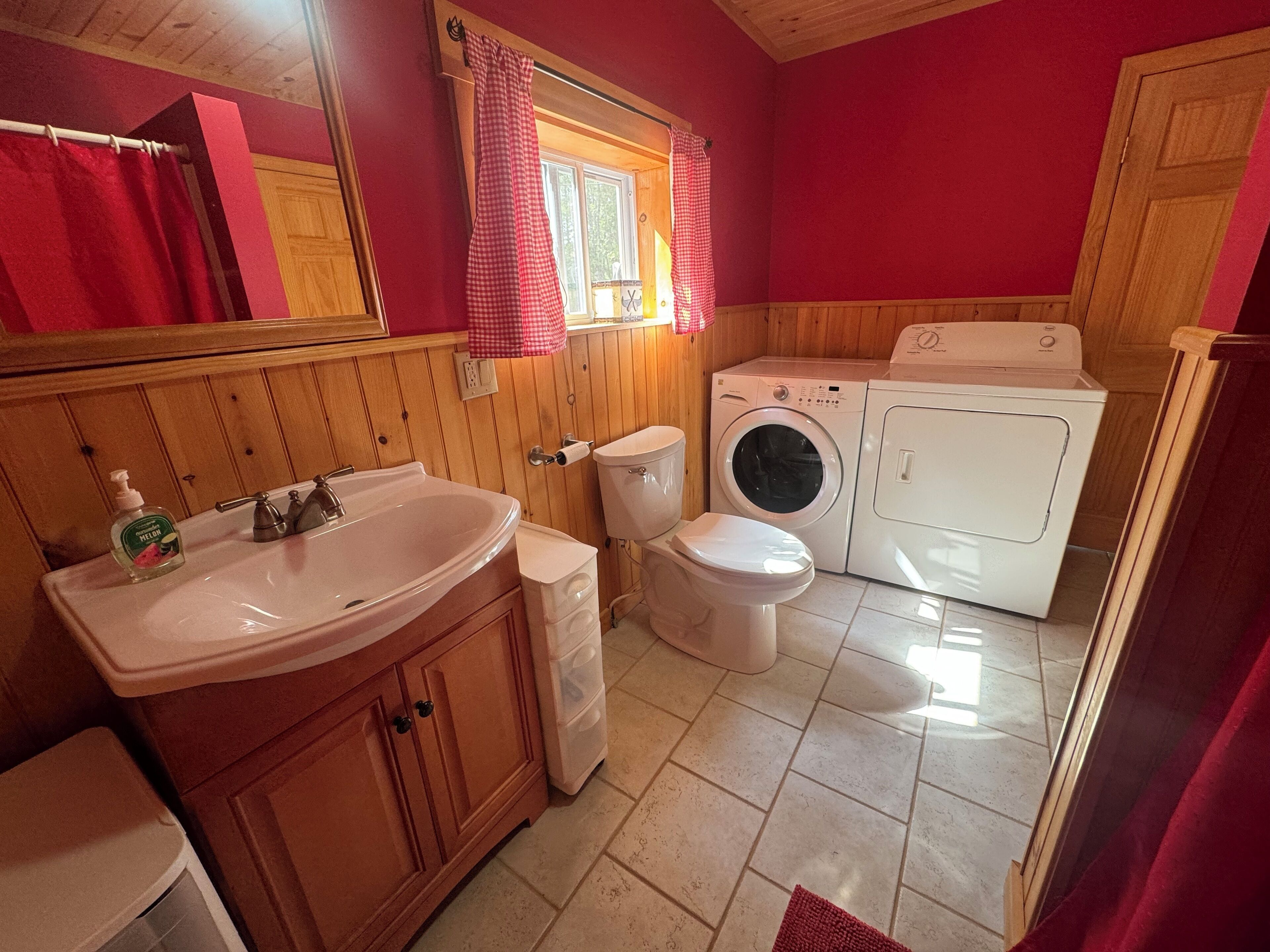 Un baño pequeño con lavamanos, inodoro y lavadora.