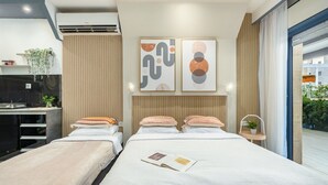 Una habitación de hotel moderna con cama, mesitas de noche, un escritorio y una obra de arte en la pared.