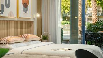 Ein Schlafzimmer mit einem Bett, Kissen, einem Nachttisch und einem Fenster mit Blick ins Freie.
