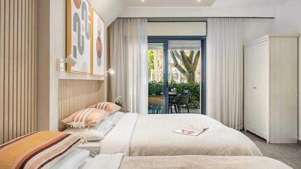 Un dormitorio moderno con una cama grande, vistas al exterior y una puerta corrediza de vidrio.