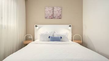 Ein Schlafzimmer mit einem Bett, Nachttischen, einer Kopfteil und Wandbildern.