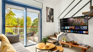 Ein modernes Wohnzimmer mit einer Couch, einem Couchtisch und einem an der Wand befestigten Flachbildfernseher.