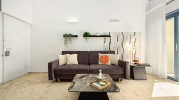 Ein modernes Wohnzimmer mit einer Couch, einem Couchtisch und einem Bücherregal.