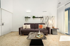A modern living room with a sofa, a coffee table, and a bookshelf.