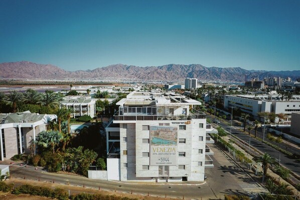 A modern building with a prominent sign for 'Venezuela' and a view of a cityscape with mountains in the background.