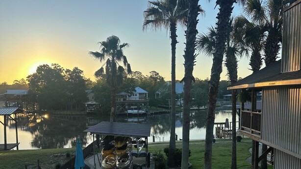 Propiedad frente al lago con muelle, sillas de descanso y zona de estar cubierta.