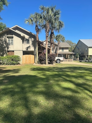 A residential area with houses, a lawn, and a white vehicle parked in front.