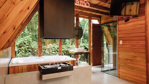 A modern wooden cabin interior with a fireplace, a television, and a neon sign reading "Te amo". - CHALÉS SUIÇOS - Românticos na Natureza para Adultos (Itapecerica da Serra)