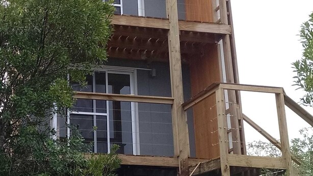 A multi-story wooden building with a balcony on the upper floor.