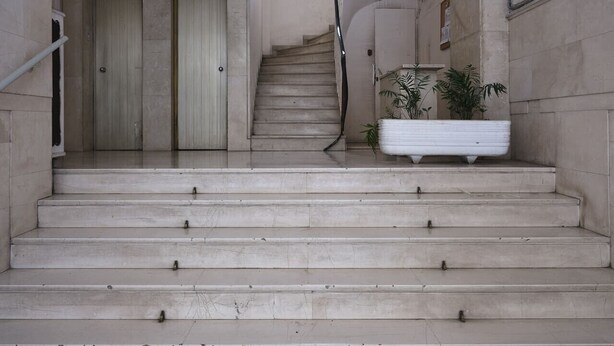 A set of marble stairs leading to a door with a window above.