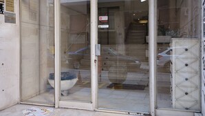 A building entrance with a glass door and a staircase leading inside.