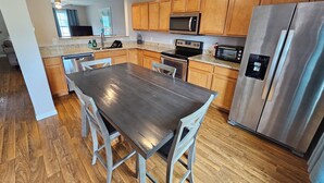 Una cucina moderna con mobili in legno, elettrodomestici in acciaio inossidabile e un piano di lavoro in granito.