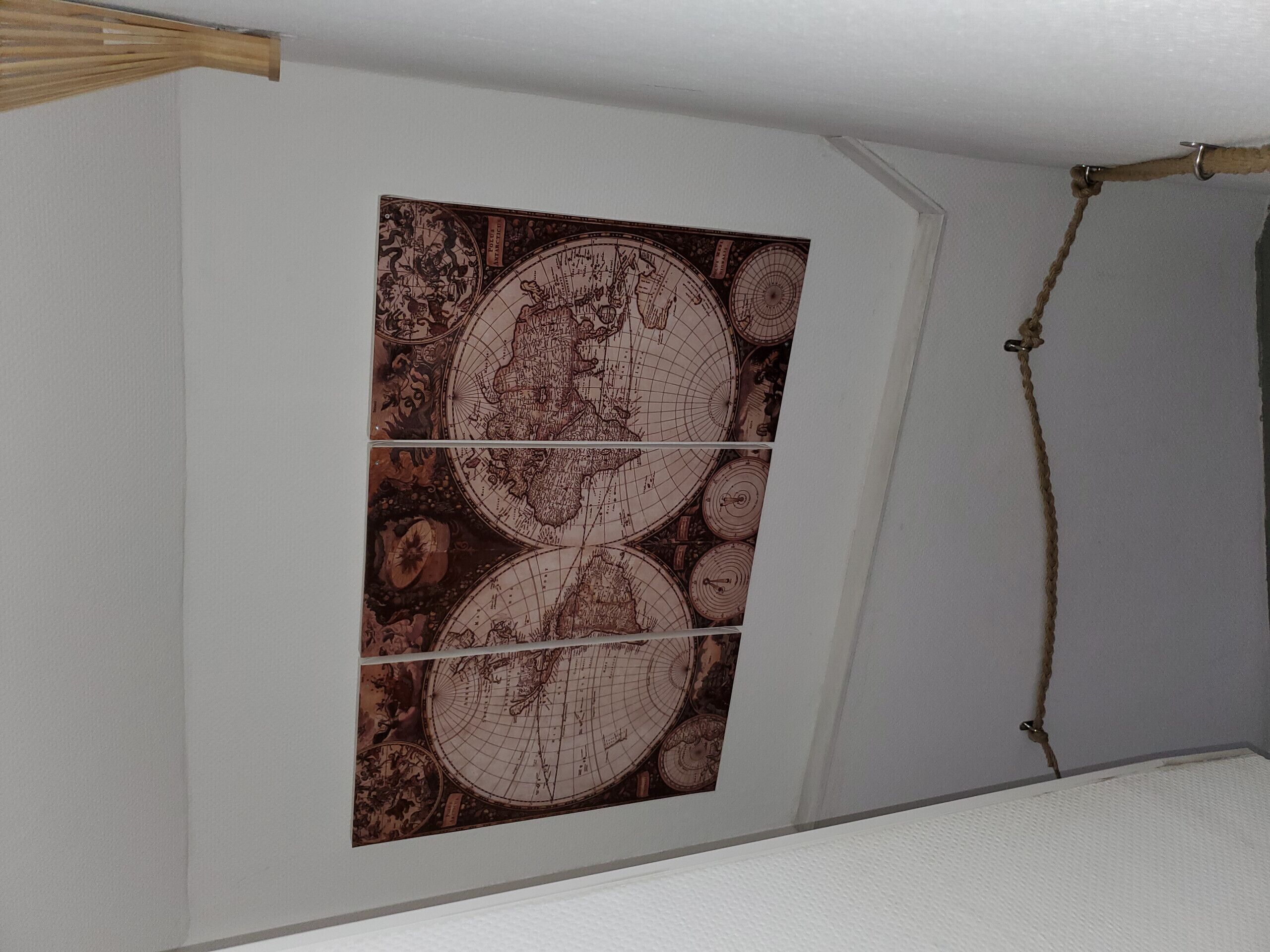Una stanza con una grande mappa a parete e una trave in legno.