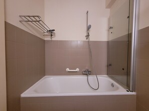 Ein Badezimmer mit Badewanne, Dusche und einer Duschkabine aus Glas.