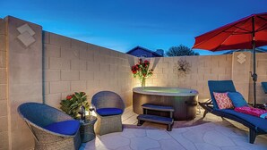 An outdoor patio with wicker chairs, a hot tub, and a red umbrella. - 5BR Hideaway w/ Heated Pool/Hot Tub/Billiards Table (Glendale)